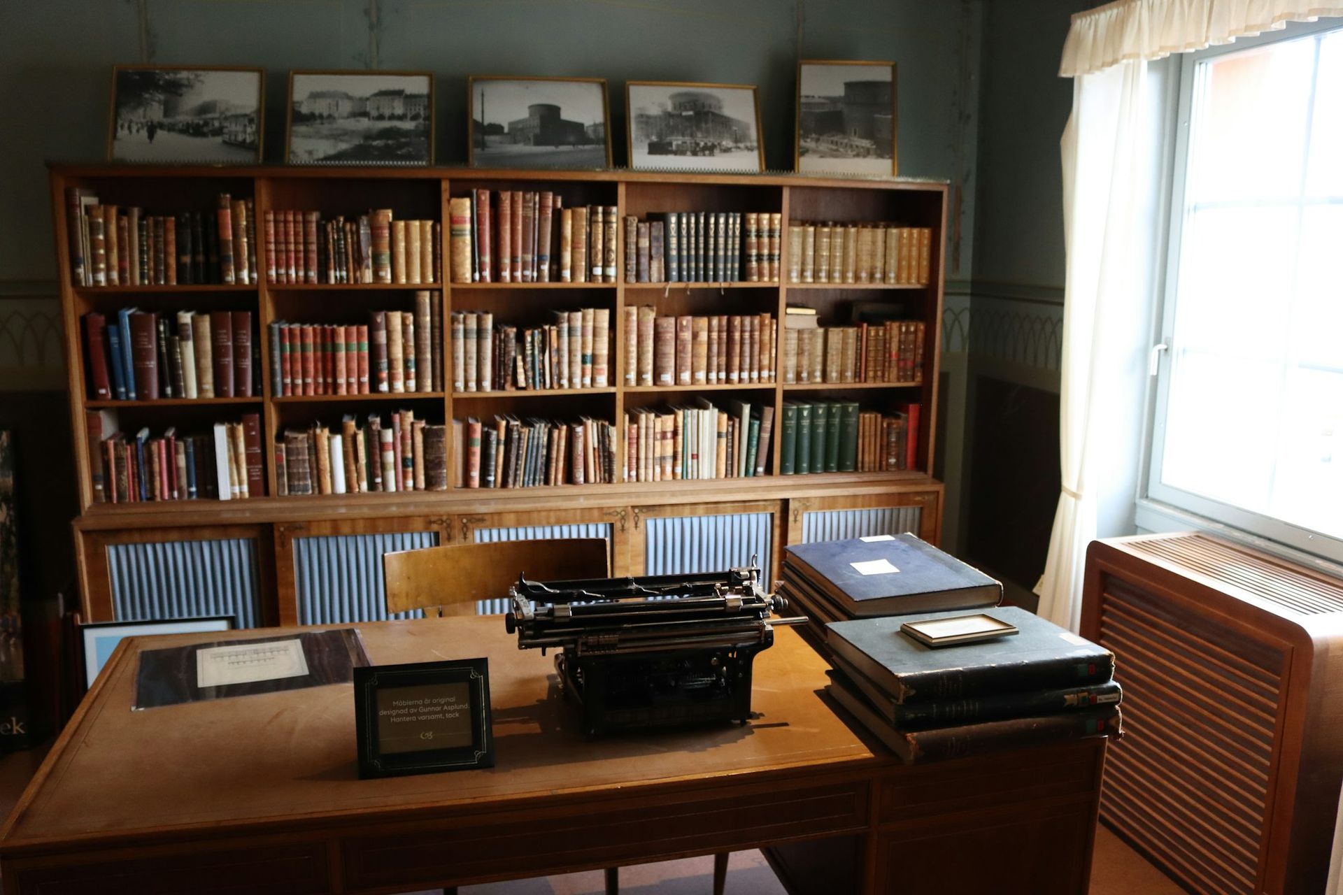 Bookshelves and a typewriter in a quiet, sunlit writing room